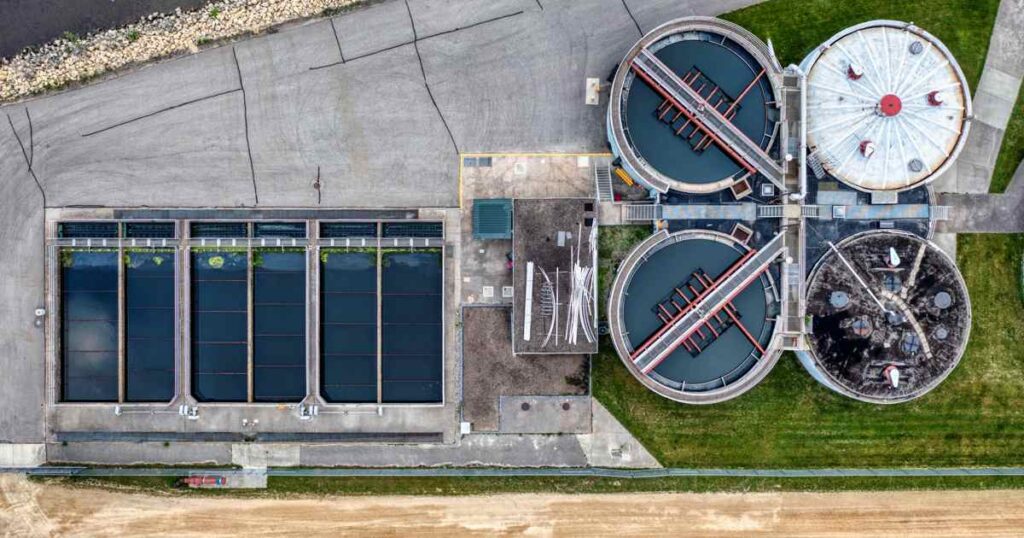 aerial view of municipal wastewater treatment plant showing circular clarifiers and aeration tanks