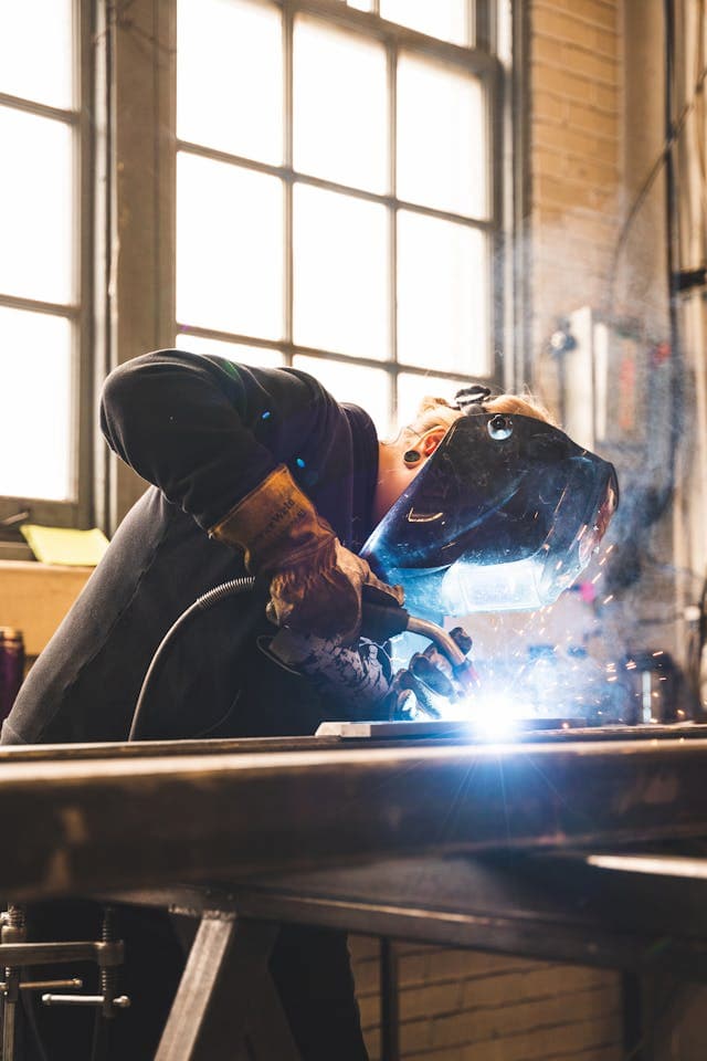 A welder using protective gear in the factory.